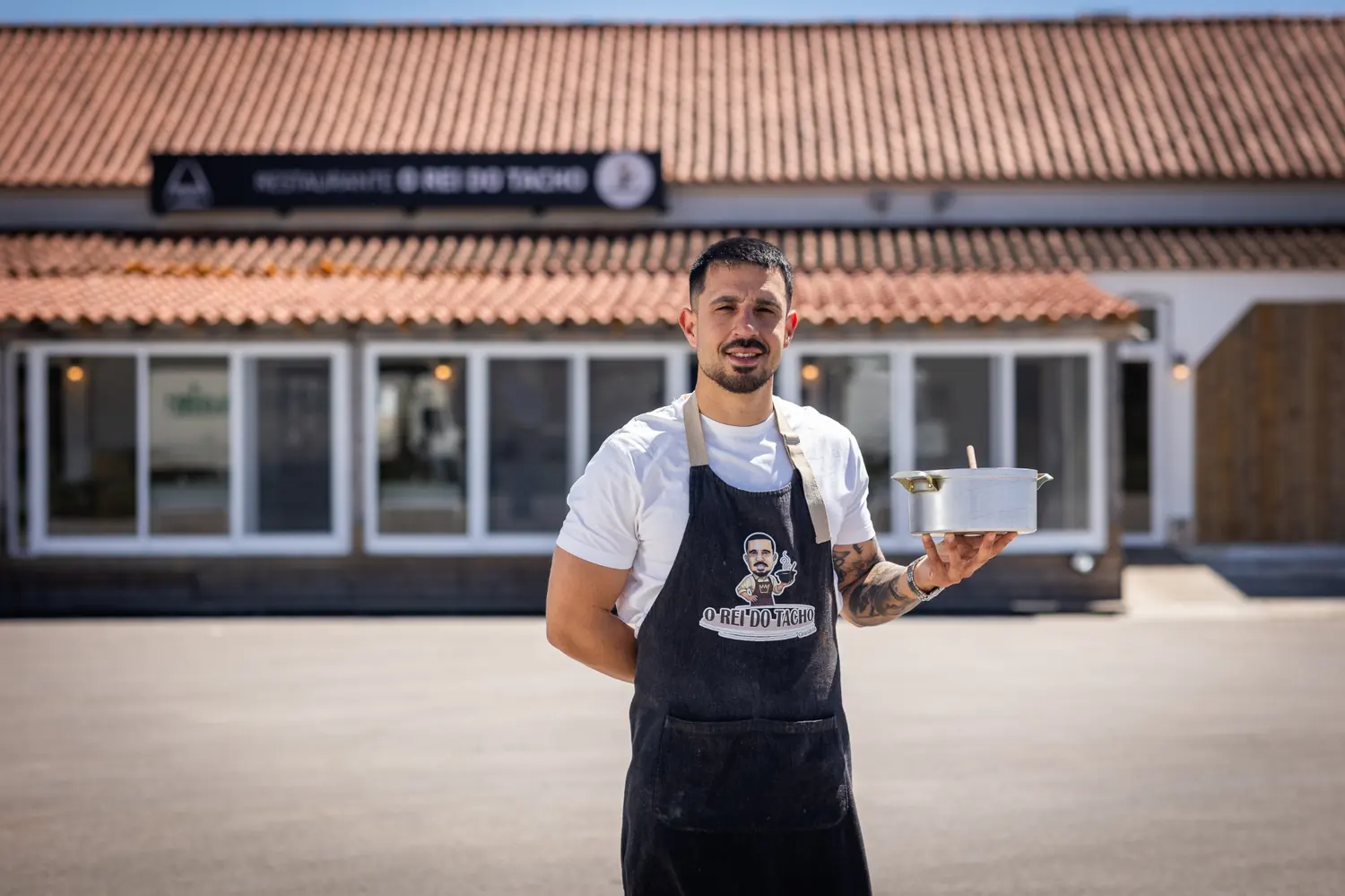 Dono do restaurante O Rei do Tacho em Grândola em frente ao restaurante com um tacho na mão
